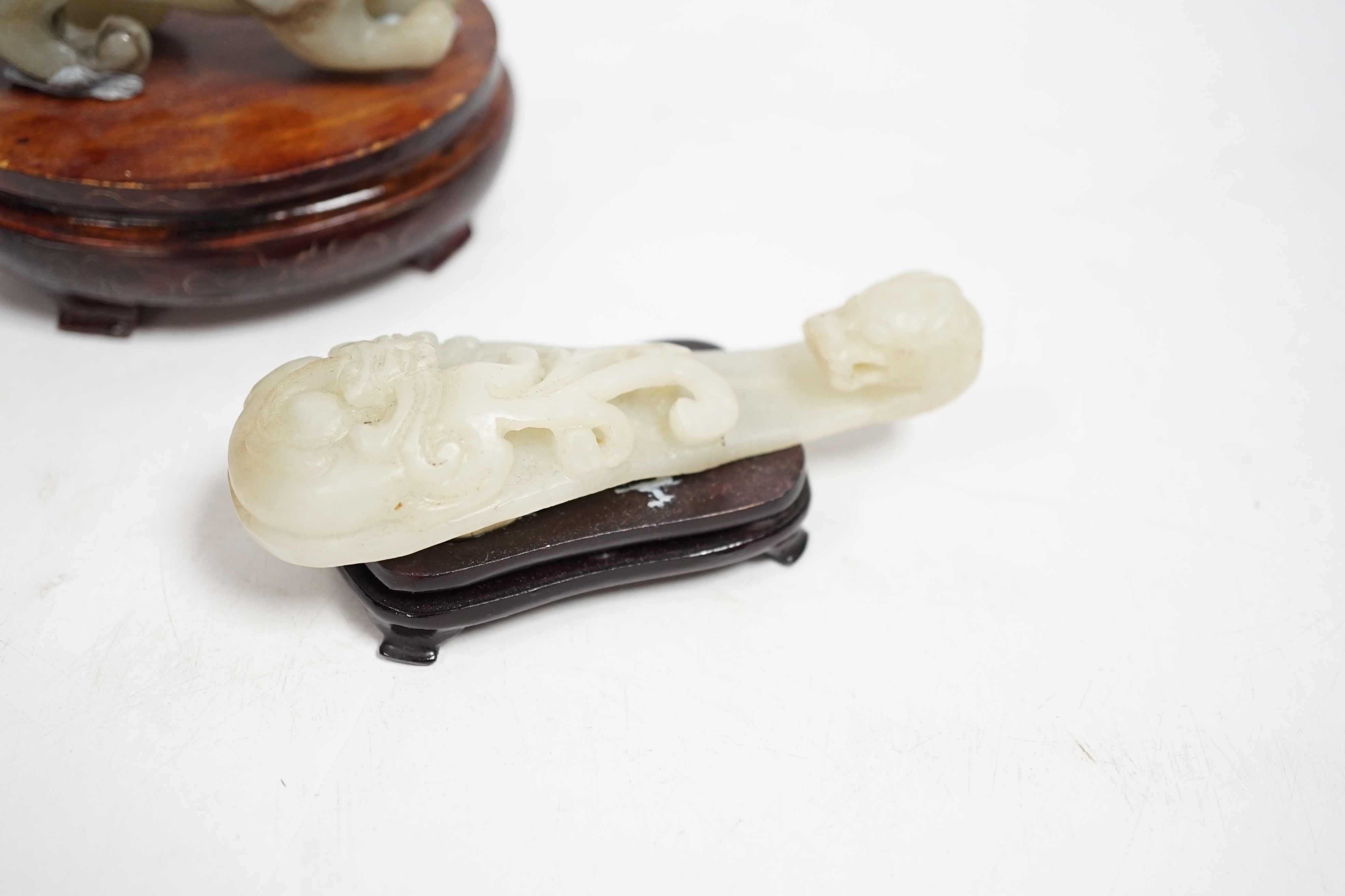A Chinese pale celadon and grey jade mythical beast on stand, and a pale celadon jade belt hook, mythical beast 11cm wide